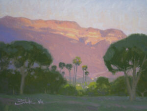 Ojai Pink Moment, giclee print by Dan Schultz. Pink sunset light on Topa Topa Bluff in the Ojai Valley, with Palm trees and other trees in the foreground.