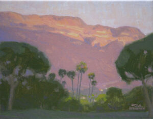 Ojai Pink Moment, giclee print by Dan Schultz. Pink sunset light on Topa Topa Bluff in the Ojai Valley, with Palm trees and other trees in the foreground.