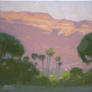 Ojai Pink Moment, giclee print by Dan Schultz. Pink sunset light on Topa Topa Bluff in the Ojai Valley, with Palm trees and other trees in the foreground.