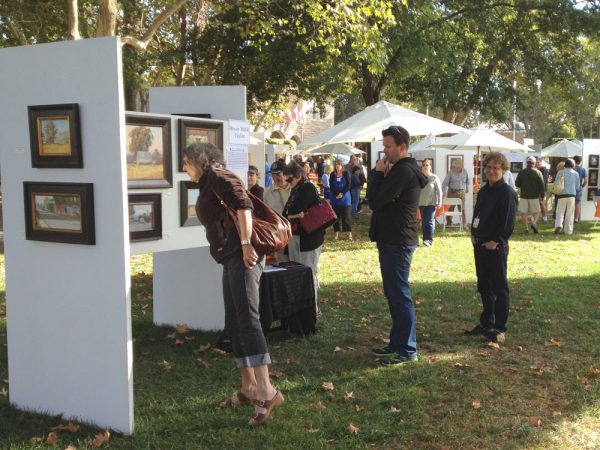 Artist Bryan Mark Taylor at his booth with interested customers at Sonoma Plein Air 2012.