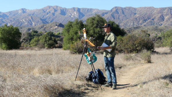 Dan Schultz painting outdoors in California with his Open Box M pochade box mounted on a camera tripod.